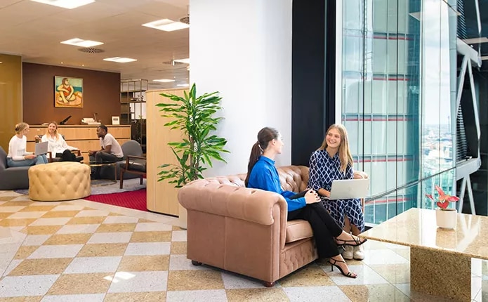 Clients working in 5-star coworking space with a stunning view and a vibrant reception.